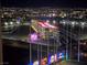 Night view of a multilevel Topgolf facility with an illuminated driving range, against the Las Vegas skyline at 135 E Harmon Ave # 2120, Las Vegas, NV 89109