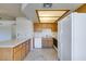 Galley kitchen with wood cabinets, white appliances, and tiled floors at 1412 Oak Rock Dr # 202, Las Vegas, NV 89128