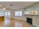 Open living room features wood floors, a ceiling fan, natural light and a stone fireplace at 1412 Oak Rock Dr # 202, Las Vegas, NV 89128