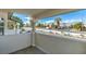 A patio with a white stucco wall and pillars, overlooking a tree-lined street with desert landscaping at 1412 Oak Rock Dr # 202, Las Vegas, NV 89128