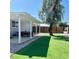 Cozy backyard featuring a covered patio with a dining set, artificial turf and a tree for shade at 2250 Red Rock St, Las Vegas, NV 89146