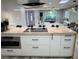 Modern kitchen island features a cooktop and place settings with tableware at 2250 Red Rock St, Las Vegas, NV 89146