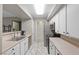 Galley kitchen showcasing white cabinets, stainless steel appliances, and tile flooring at 2300 E Silverado Ranch Blvd # 1059, Las Vegas, NV 89183