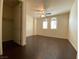 Bedroom with ceiling fan, dark wood floors, and arched windows with plantation shutters at 2405 Serene Ave # 241, Las Vegas, NV 89123