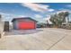 Exterior elevation of home with a long driveway and detached garage featuring a bright red garage door at 3905 Casa Grande Ave, Las Vegas, NV 89102