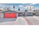 Single-story home featuring a bright red garage door, well-manicured landscaping, and a inviting facade at 3905 Casa Grande Ave, Las Vegas, NV 89102