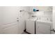 This laundry room features a white washer and dryer with built in shelving and extra storage space at 3924 E Garfield Dr, Pahrump, NV 89061