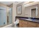 Bathroom featuring tiled floor, glass enclosed shower, and vanity with black marble countertop at 399 Placer Creek Ln, Henderson, NV 89014