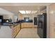 Kitchen with tile floors, light wood cabinets, and black appliances at 399 Placer Creek Ln, Henderson, NV 89014