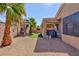 Desert landscaped backyard with decorative palms, artificial turf, and privacy wall at 4012 Shetland Pony St, Las Vegas, NV 89122