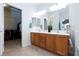 Bright bathroom with a double sink vanity, walk-in closet, and neutral tile flooring at 4012 Shetland Pony St, Las Vegas, NV 89122