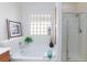 Bathroom featuring a soaking tub with tile surround, glass block window, and glass shower at 4012 Shetland Pony St, Las Vegas, NV 89122