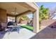 Outdoor covered patio with palm trees, artificial turf, gravel, and shaded seating area at 4012 Shetland Pony St, Las Vegas, NV 89122