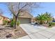 Charming stucco home featuring mature landscaping, a two-car garage, and a paved driveway at 4012 Shetland Pony St, Las Vegas, NV 89122