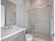Bathroom with glass shower, neutral tiles, modern faucet, and gray vanity at 4880 Argento Peak St, Las Vegas, NV 89135