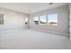 Spacious bonus room with soft carpeting, neutral walls, and multiple windows at 4880 Argento Peak St, Las Vegas, NV 89135