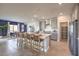 Modern kitchen with gray cabinetry, a large island with seating, stainless steel appliances, and an open dining area at 518 Copper Falcon Ave, Henderson, NV 89011