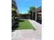 Backyard featuring artificial turf, mature landscaping, and a covered patio at 5830 Springmist St, North Las Vegas, NV 89031