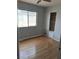 A cozy bedroom featuring hardwood floors, closet with sliding doors, and natural light at 5830 Springmist St, North Las Vegas, NV 89031