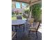 Covered patio features a stone paver floor, a round stone table and 4 chairs at 5830 Springmist St, North Las Vegas, NV 89031