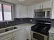 Modern kitchen features a stainless steel oven and microwave, complimented by a double sink and white cabinetry at 6743 W Charleston Blvd # 4, Las Vegas, NV 89146