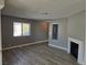 Bright living room features modern wood-look tile flooring, neutral paint, and a charming fireplace at 6743 W Charleston Blvd # 4, Las Vegas, NV 89146