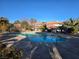 Community pool surrounded by mature trees, bushes, and desert landscaping at 6743 W Charleston Blvd # 4, Las Vegas, NV 89146