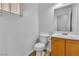 Cozy powder room with white fixtures, vanity and window at 6949 Copper Bracelet Ave, Las Vegas, NV 89122