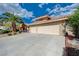 Spacious three-car garage with ample parking space in front, set against a bright blue sky with scattered clouds at 7724 Clearwood Ave, Las Vegas, NV 89123
