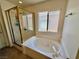 Large bathtub and shower with a glass door in a well lit bathroom at 8461 Faucet Ave, Las Vegas, NV 89147