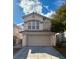 Two-story home features a two-car garage, tile roof, desert landscaping, and a charming stucco exterior at 8461 Faucet Ave, Las Vegas, NV 89147