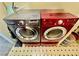 The image showcases a pair of laundry machines, one gray and one red at 8461 Faucet Ave, Las Vegas, NV 89147