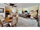 Open floor plan boasts a combined kitchen, dining, and living area with carpeted floors and plenty of natural light at 8461 Faucet Ave, Las Vegas, NV 89147