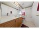 Bright bathroom featuring a single sink vanity and shower over tub with poppy-themed curtain at 8533 Last Point Ave, Las Vegas, NV 89129