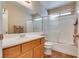 Well-lit bathroom featuring wooden cabinets, a tub-shower combo, and modern fixtures at 8566 Manalang Rd, Las Vegas, NV 89123