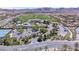 Aerial view of community clubhouse, pool, parking, tennis courts and golf course at 9 Promenade Isle Ln, Henderson, NV 89011
