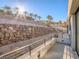 Features include stone wall with mature palm trees and other drought tolerant landscaping at 9 Promenade Isle Ln, Henderson, NV 89011