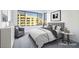 This bedroom is virtually staged with a large window and grey and white decor at 9 Promenade Isle Ln, Henderson, NV 89011