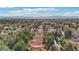 A scenic view of a community with lush trees, red tile roofs and cityscape in the distance at 9044 Opus Dr, Las Vegas, NV 89117