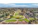 Panoramic view of a golf community, with beautiful homes lining the course, enhanced by mature trees and a serene lake at 9044 Opus Dr, Las Vegas, NV 89117