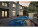 Evening shot of inviting backyard with pool, spa, covered patio, and outdoor fireplace at 9044 Opus Dr, Las Vegas, NV 89117