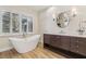 This stunning bathroom features a soaking tub, a large vanity, and natural light at 9044 Opus Dr, Las Vegas, NV 89117