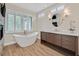 Modern bathroom with soaking tub, wood-style flooring, and custom vanity at 9044 Opus Dr, Las Vegas, NV 89117