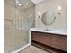 Modern bathroom featuring a glass shower, stylish vanity with drawers, and a round mirror at 9044 Opus Dr, Las Vegas, NV 89117