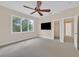 Bedroom with neutral carpet, ceiling fan, and large window with view of trees at 9044 Opus Dr, Las Vegas, NV 89117