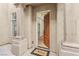 Welcoming entryway with a solid wood door, tile flooring, and views into the home's interior at 9044 Opus Dr, Las Vegas, NV 89117