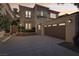 A charming two-story home at dusk with a brown garage door, tiled roof, and landscaped front yard at 9044 Opus Dr, Las Vegas, NV 89117