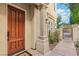 Inviting home exterior with a solid wood front door, a decorative gate, and manicured landscaping at 9044 Opus Dr, Las Vegas, NV 89117