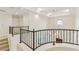 Spacious hallway with chandelier and black metal railing overlooking the lower level at 9044 Opus Dr, Las Vegas, NV 89117