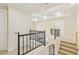 Hallway with a black metal railing and carpeted stairs leading to the upper level at 9044 Opus Dr, Las Vegas, NV 89117